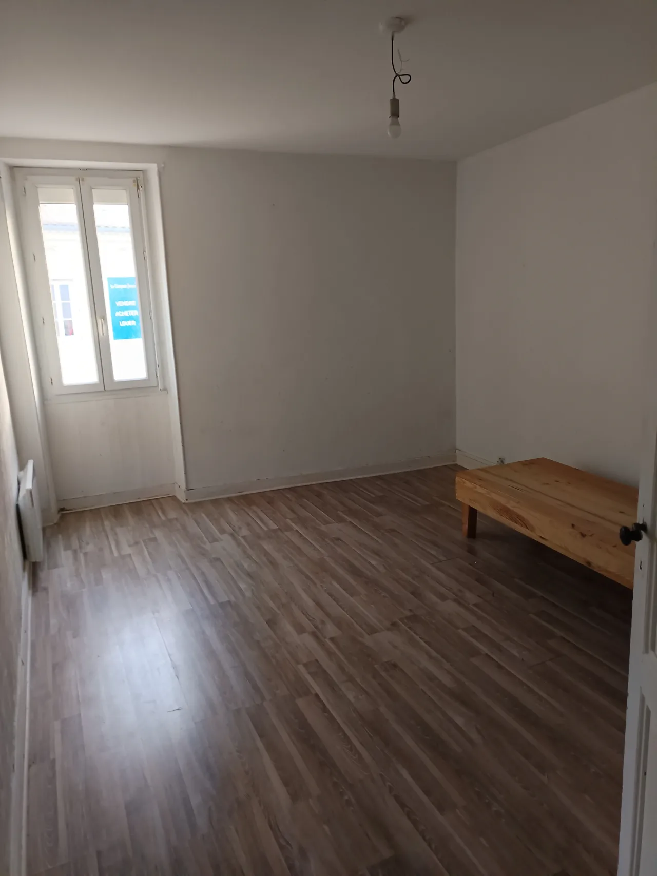 Chambre aux murs clairs et au sol brun