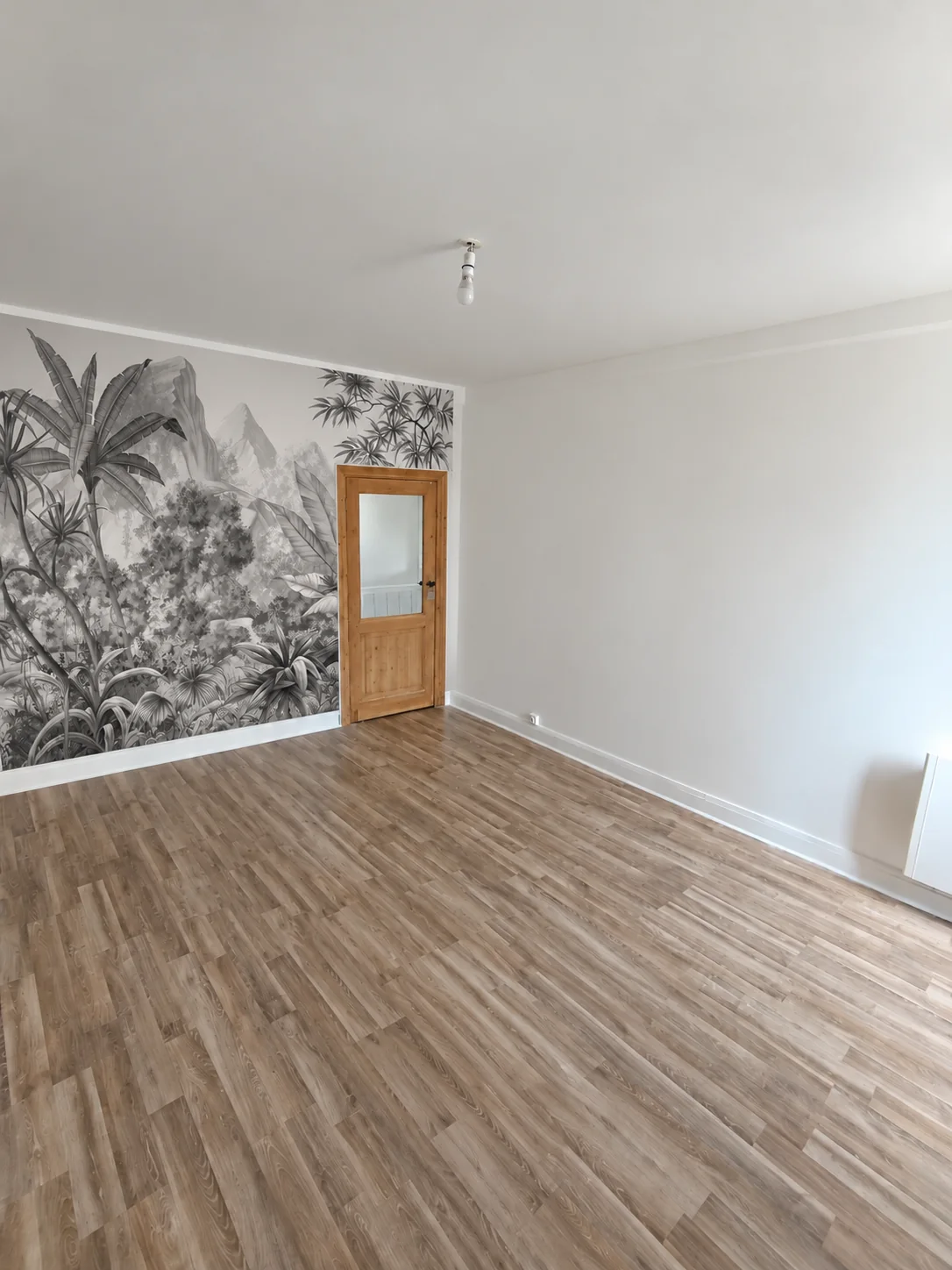 Papier peint panoramique à motifs de feuillage dans une pièce lumineuse
